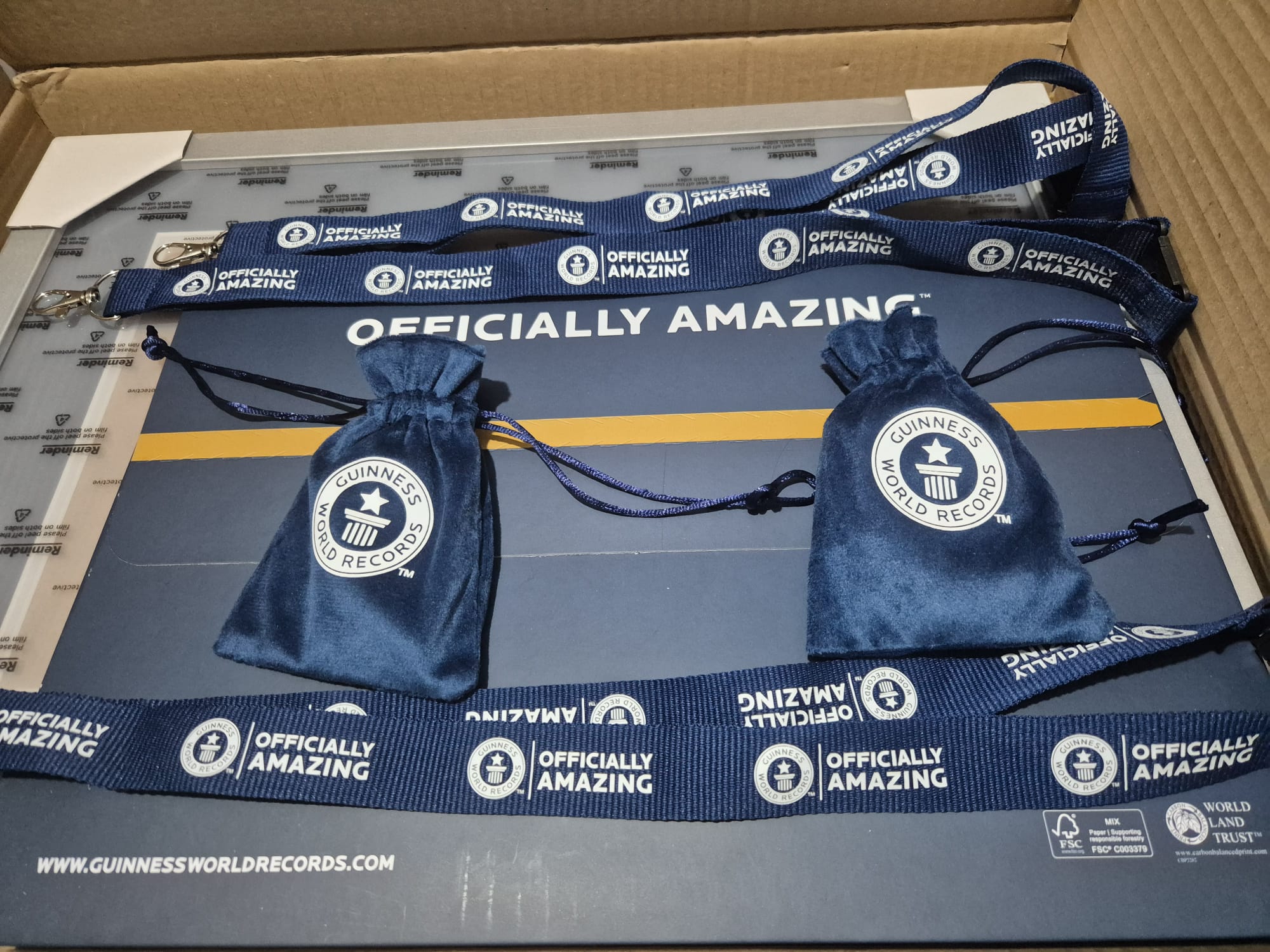 A Guinness World Records parcel with certificates, lanyards and record holder pouches