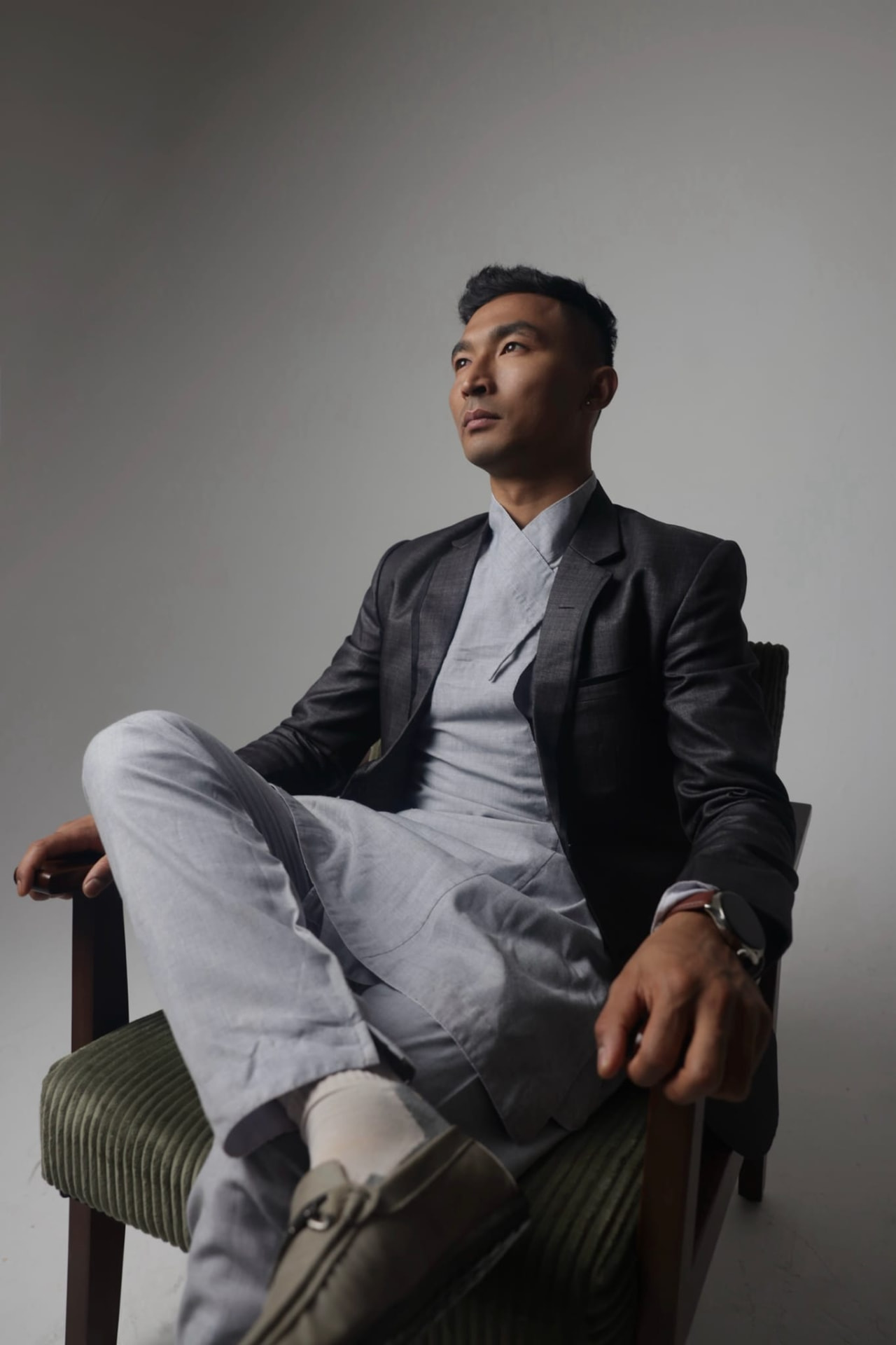 Sajan Dangol seated in a studio portrait wearing a dark jacket